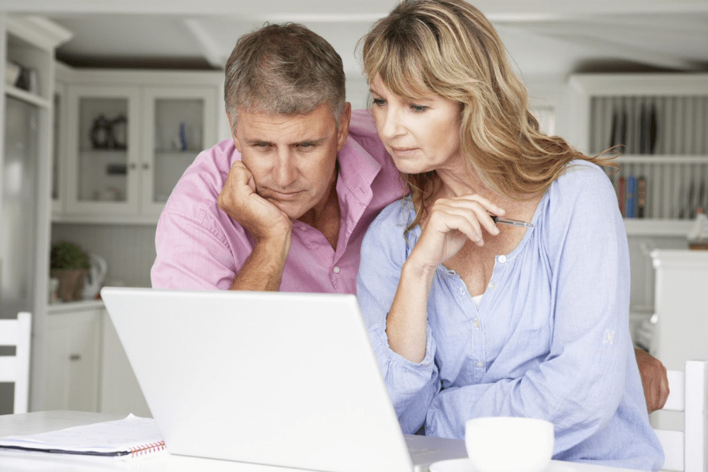 older couple looking at laptop reading article on consolidating superannuation